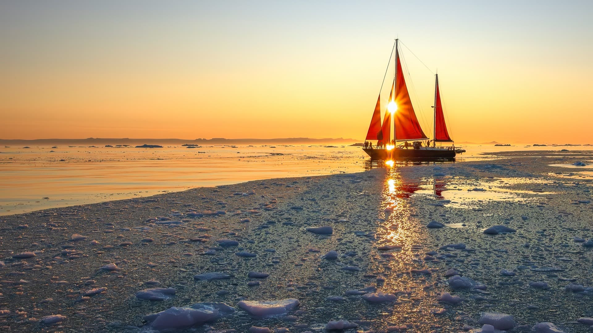 Midnight sun bursting through crimson sails of a schooner navigating brash ice in Greenland