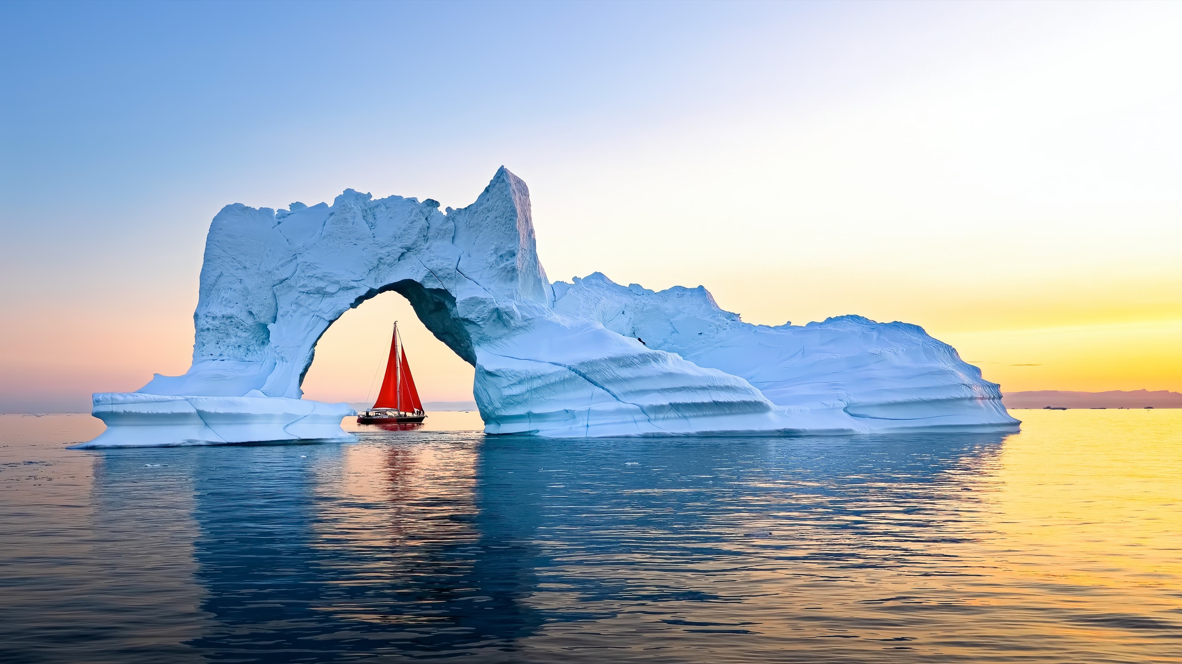 Red sailboat among icebergs in Ilulissat Icefjord, Greenland